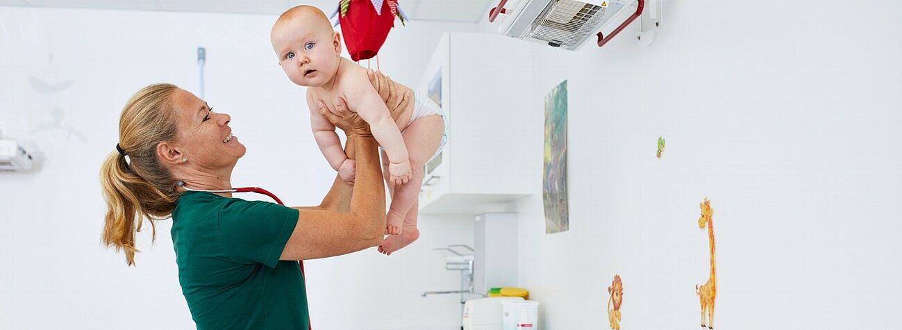 Kinderärztin untersucht einen Säugling.